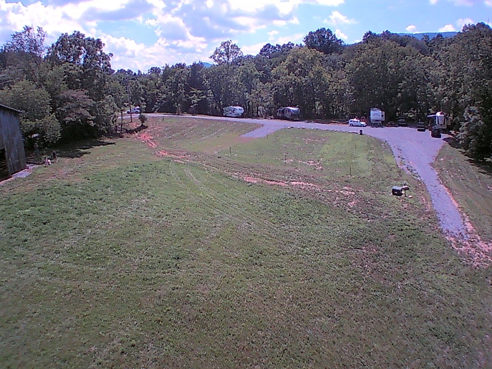 Aerial view of the campground field, with RVs along the gravel loop by the tree line