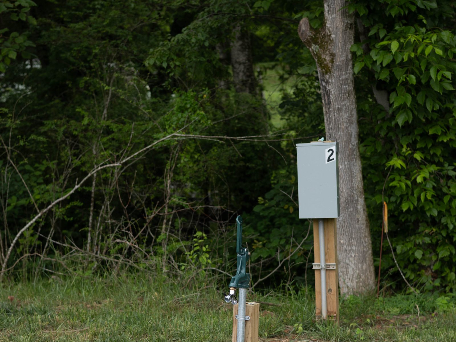 A campsite hookup post with its power box and water hydrant